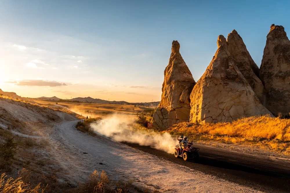 Group of tourists riding ATVs in the desert between rock formations for a piece on whether or not Cappadocia is safe to visit