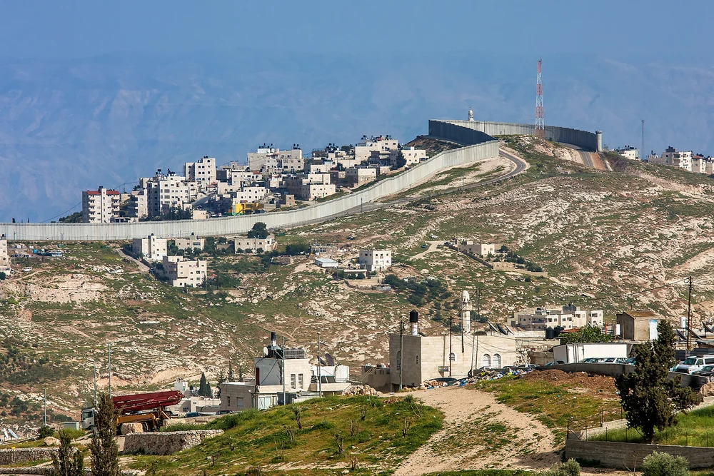 Small border divider and tower overlooking the border of Palestine and Israel in the West Bank