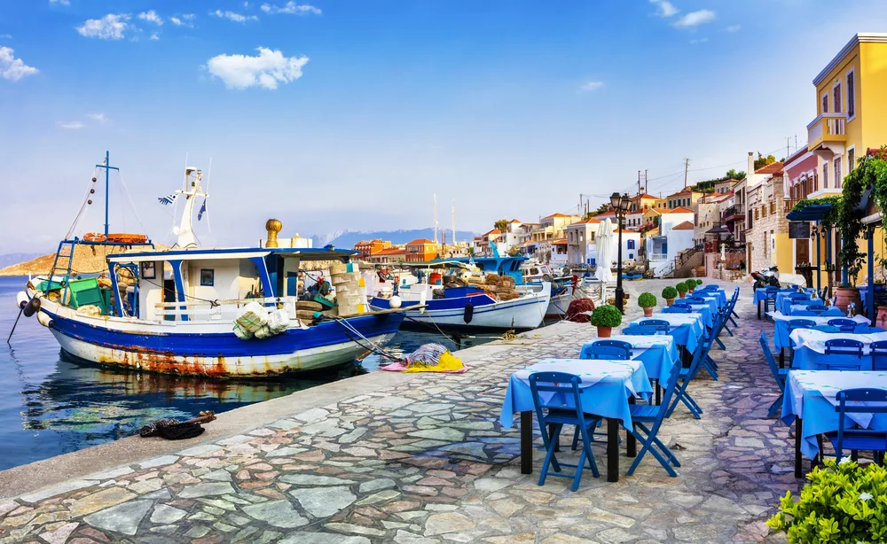 Traditional white and blue fishing boats pictured in the harbor at Chalki, pictured on a clear day