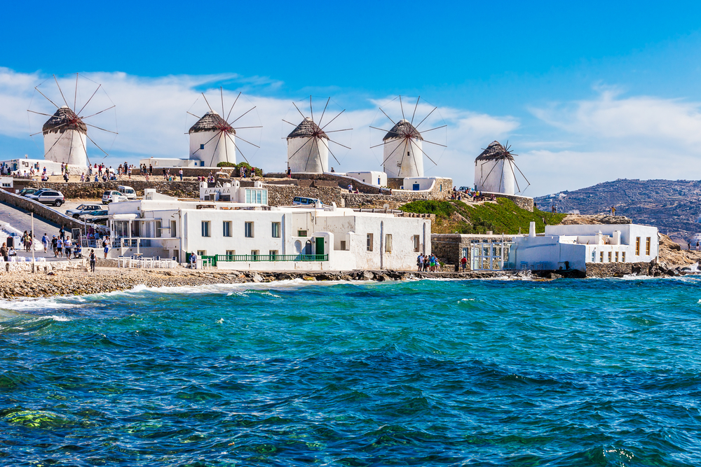 The famous windmills near the Old Port on a clear, sunny day during the overall best time to visit Mykonos in spring and early summer