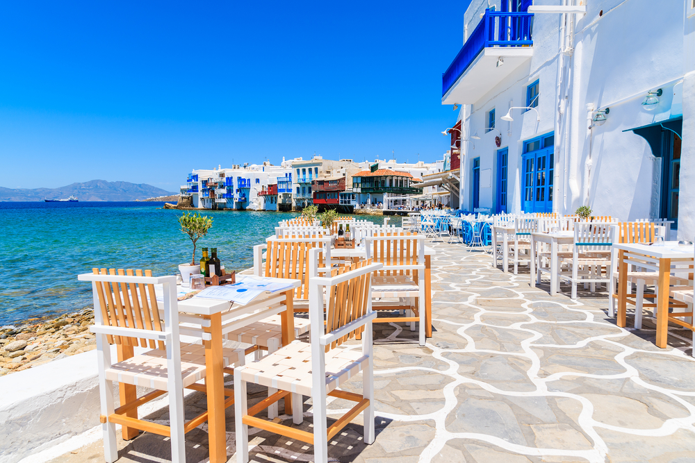 Empty outdoor dining tables at a Greek restaurant in Little Venice neighborhood during the best time to visit Mykonos
