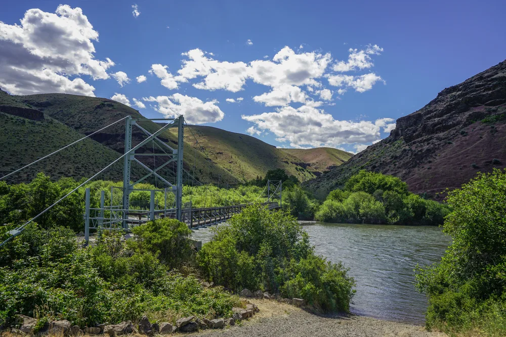 Photo of a metal suspension bridge spanning the Yakima River