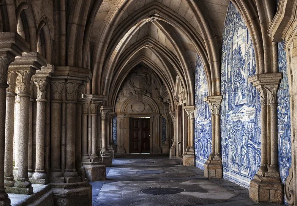 Amazing architectural arches in the historic city center with blue and white azulejo tiles lining the walls to indicate why you should visit Porto, Portugal