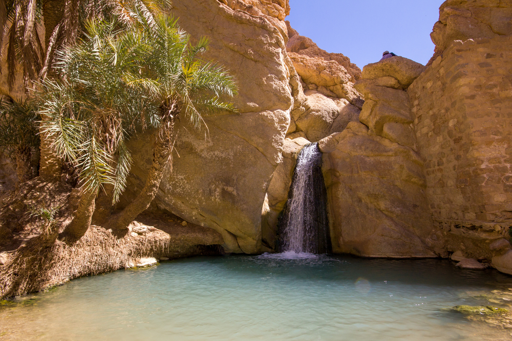 Waterfall in a desert oasis in the Sahara to show the least busy time to visit Tunisia