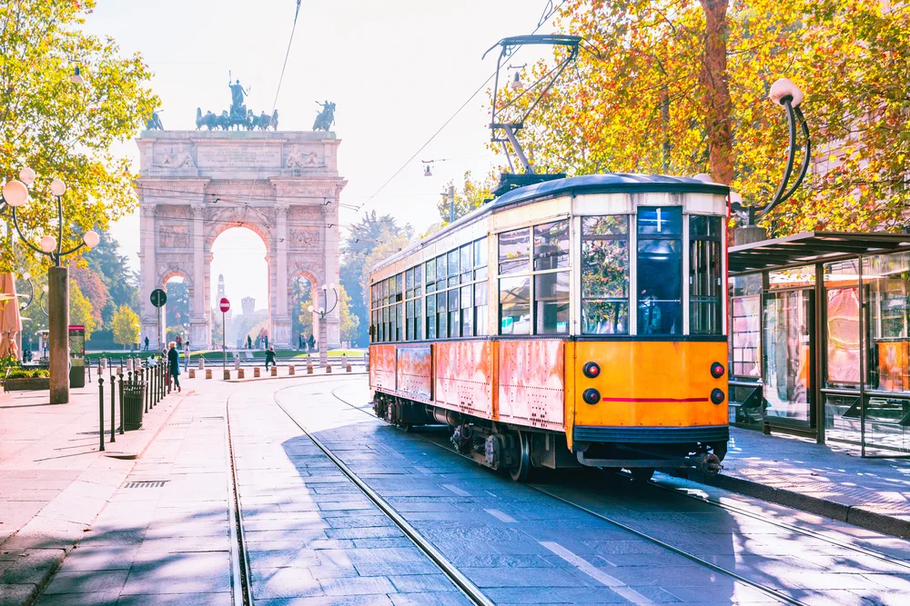 Vintage tram with the Arch of Peace in the background on a fall day during the least busy time to visit Milan