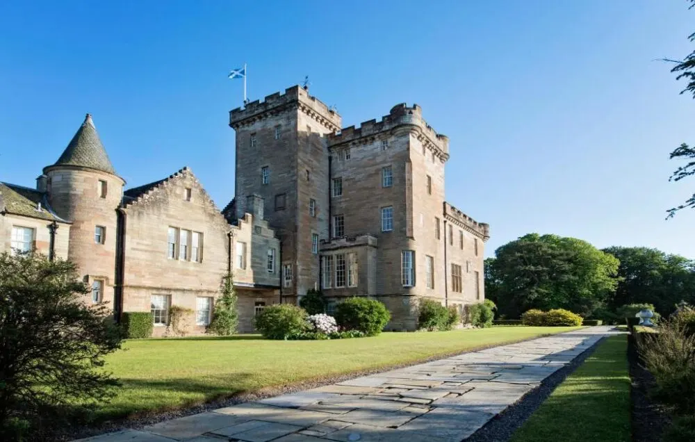 Exterior of the Glenapp Castle, a top pick for the top castle hotels in Scotland, pictured from the stone walking path in front