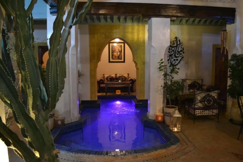 For a roundup of the best riads in Marrakech, a photo of the blue pool and the open-air courtyard at the Riad Bayti