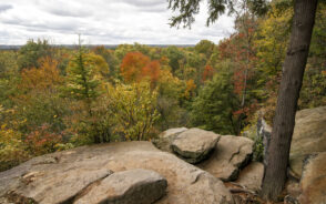 Autumn view of the valley below for a piece titled the best time to visit Cuyahoga Valley National Park, as seen during the best time to visit, with rock formations on the edge of the valley