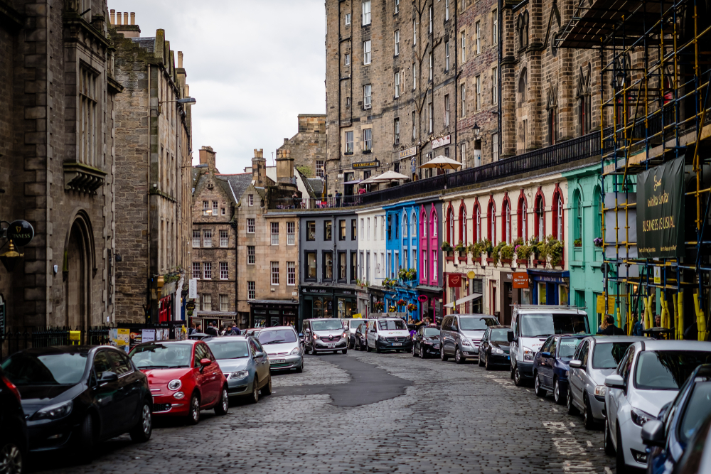 Photo of cars lining the stone street in Cowgate in Old Town, one of the best areas to stay when in Edinburgh