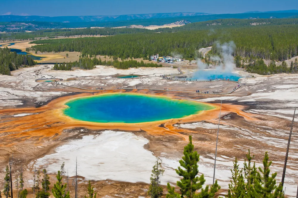 Yellowstone National Park's Grand Prismatic Spring shown from above on a sunny day in the park, listed as one of the best vacation spots in the US