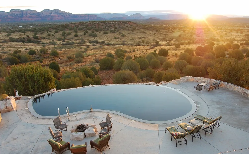 Aerial view of an infinity pool overlooking the red rocks in Sedona at a retreat, listed as one of the best places to go for your birthday