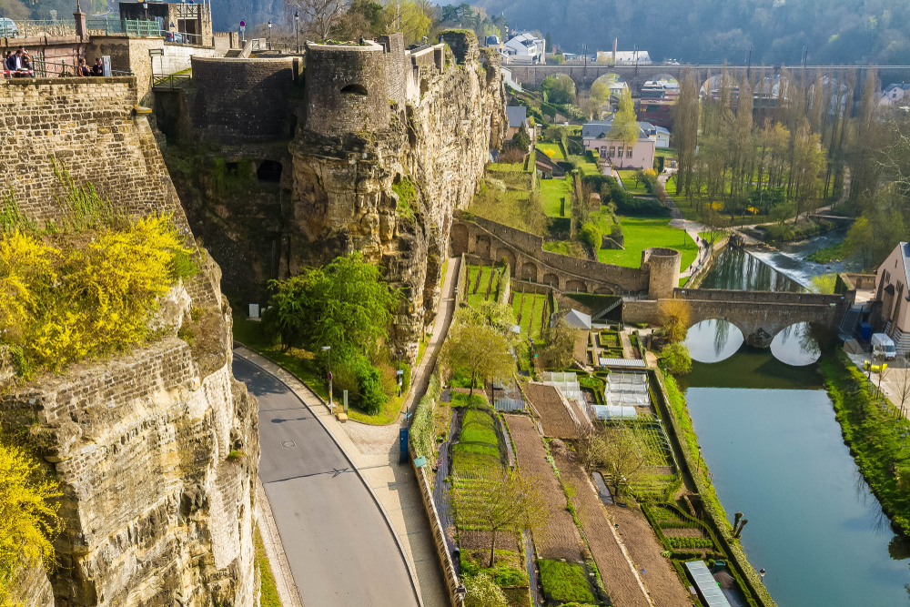 Panoramic aerial view of Luxembourg pictured with the old stone bridge spanning the river and the walled city towering over the scene below 