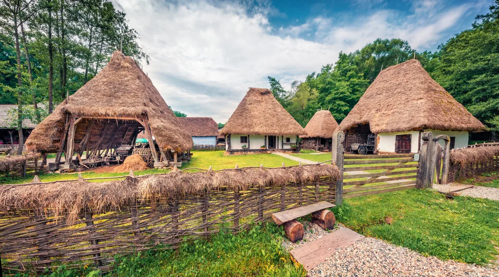 Cute little peasant houses with thatched roofs seen on a nice day during the least busy time to visit Romania