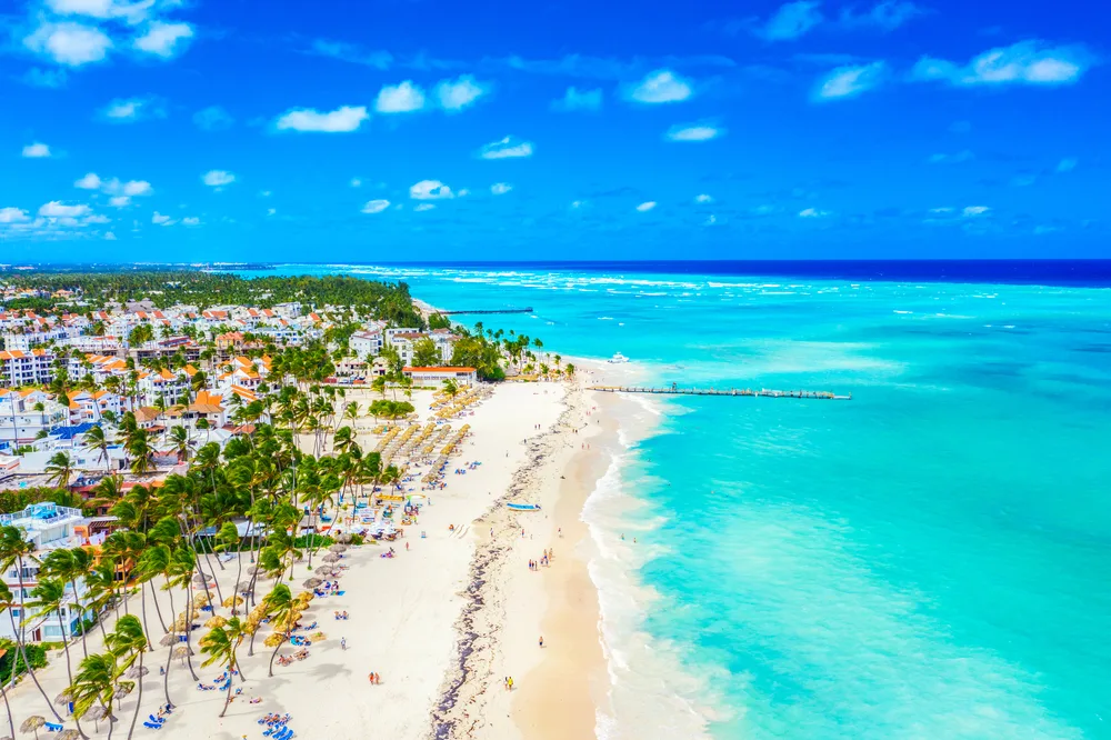 Aerial view of Bavaro Beach in Punta Cana, Dominican Republic on a sunny day with tourists on the shore to indicate one of the best birthday trip destinations