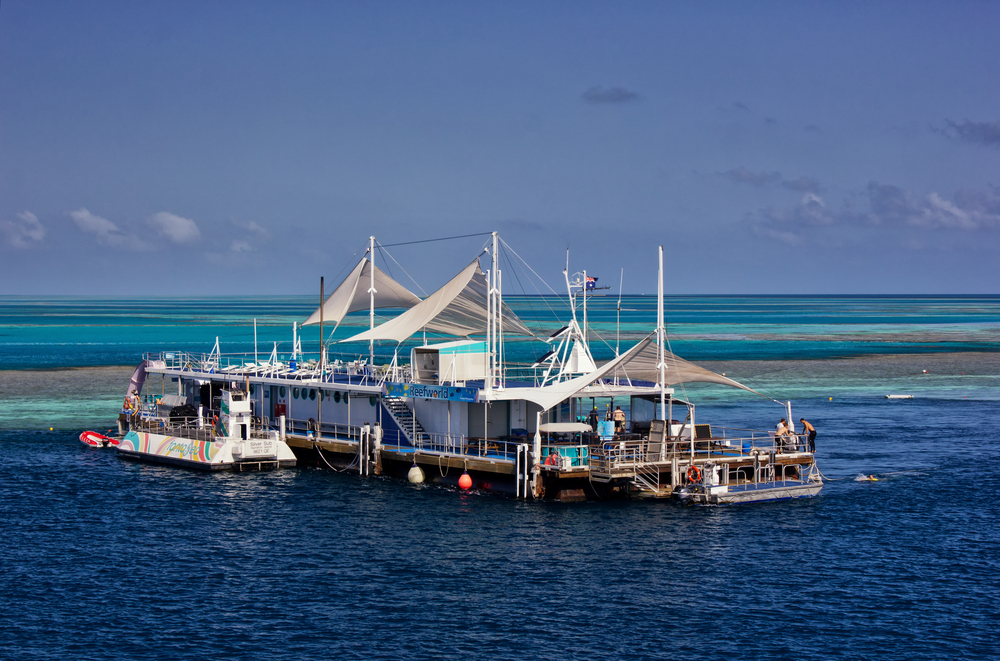 Two boats moored over the Great Barrier Reef to illustrate that commercial boats pollute the waters