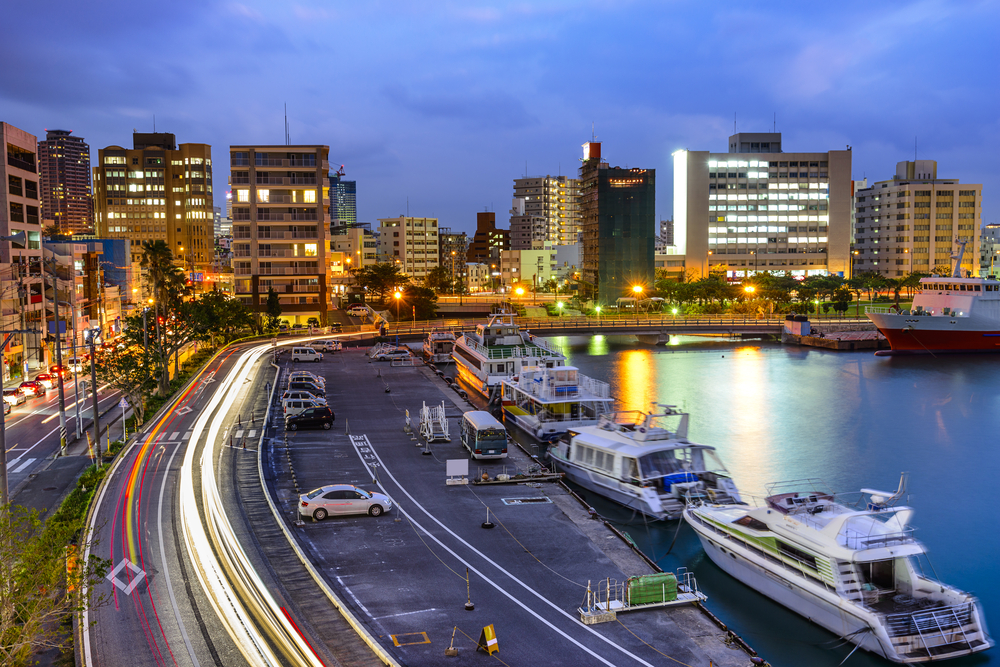 Low-shutter image of Naha in Okinawa featuring the Tomari Port at night with boats floating on the still water