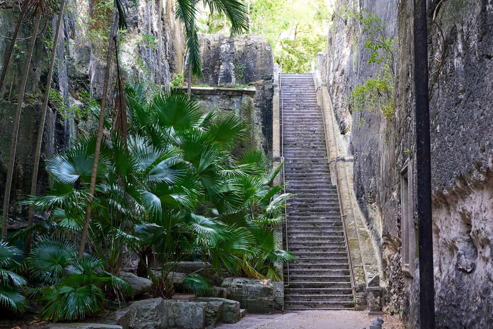 Queens Staircase in Nassau pictured for a piece titled Are the Bahamas Safe to Visit with a dark area next to trees