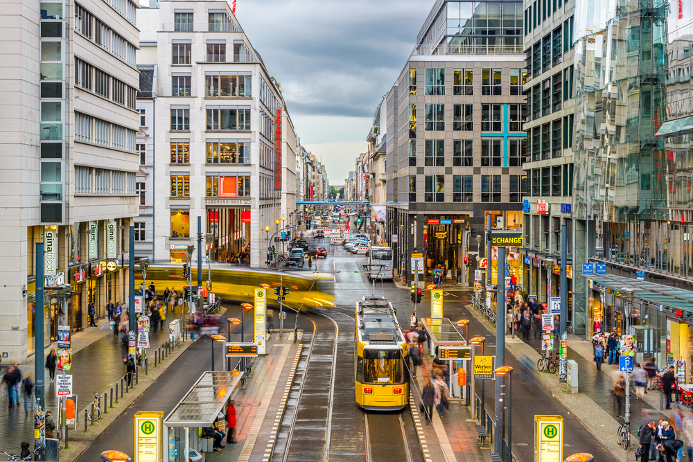 Slightly elevated view of the Friedrichstrasse Shopping Center pictured below a cloudy sky for a piece titled Is It Safe to Visit Berlin