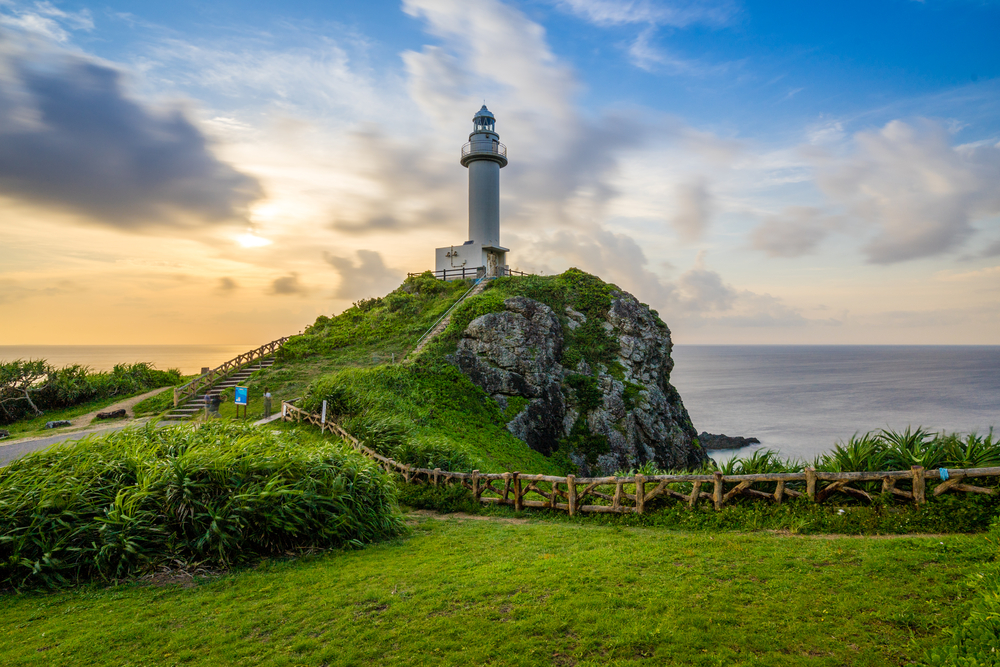 Picturesque shot of the Ishigaki Island lighthouse pictured during the best time to visit Okinawa with a sunset in the background