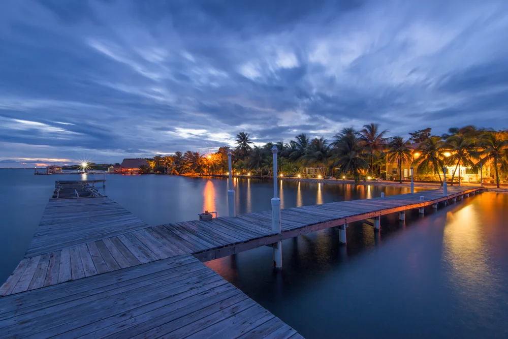 For a guide to whether or not Belize is safe to visit, the sun sets over the well-lit boardwalk in Placencia