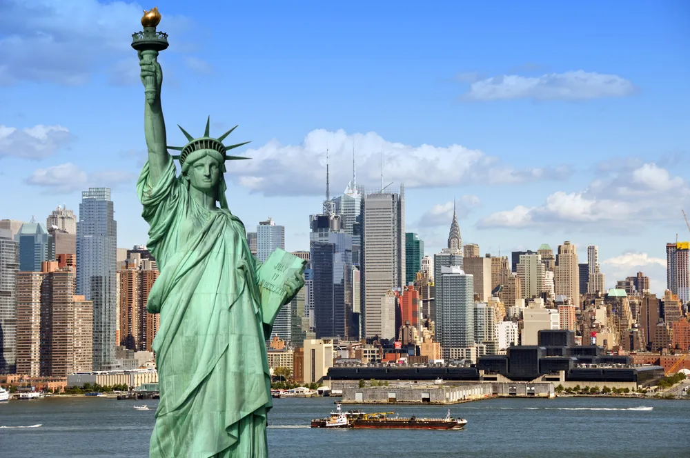New York City is one of the cheap places to fly to in the US, shown here with the Statue of Liberty in front of the skyline