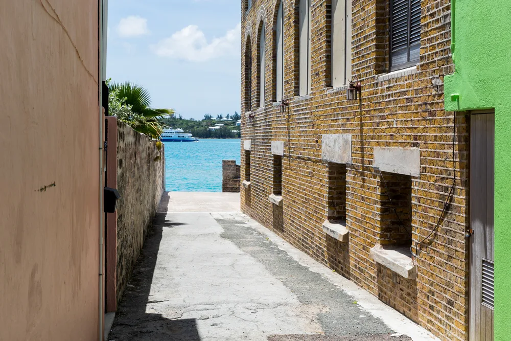 Small alleyway leading to the ocean between two brick buildings for a piece titled Is Bermuda Safe to Visit