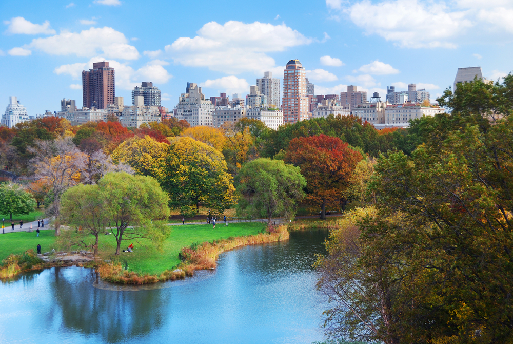 New York City view of Manhattan's Central Park in fall overlooking a lake on a nice day to show NYC as one of the best US vacations you can take