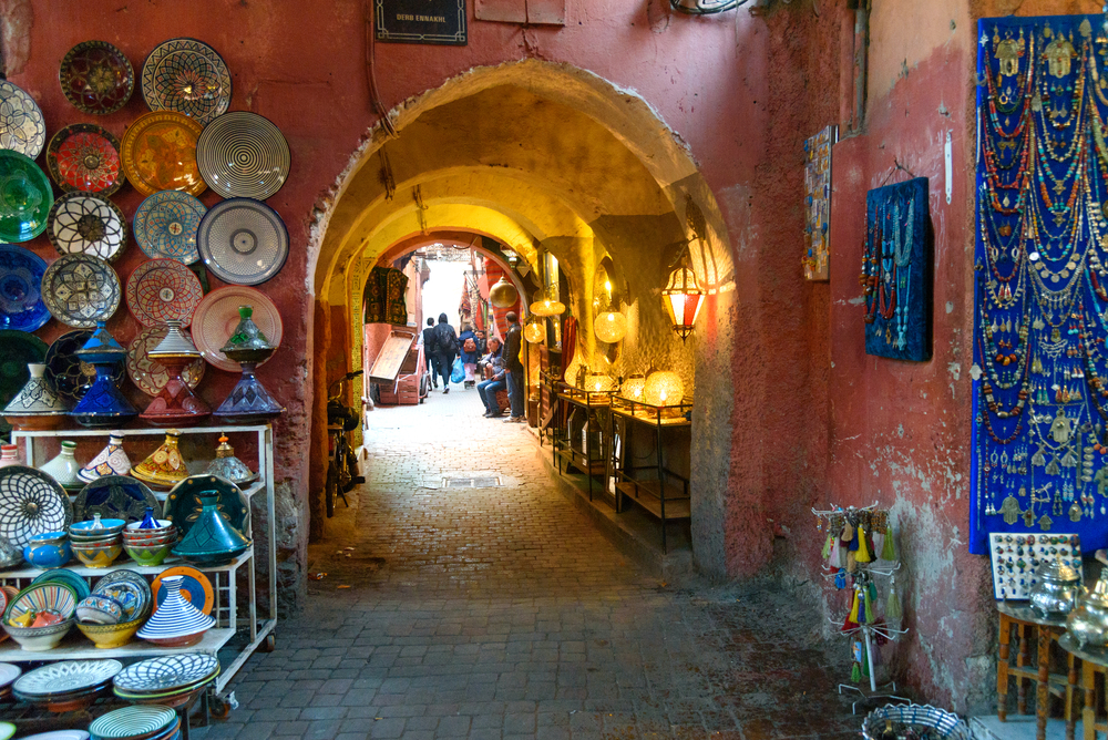 View of a colorful Marrakech market in Morocco looking through alley archways for a piece showing the 10 best riads in Marrakech