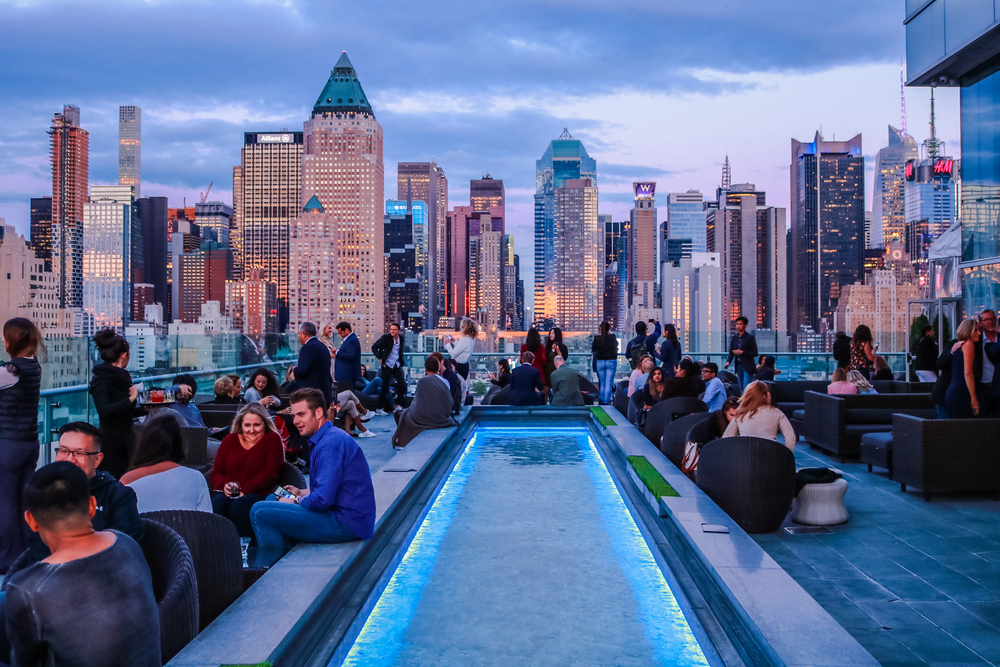 Rooftop bar in New York City seen at dusk with the skyline in the distance shows one way to spend a great birthday in the city