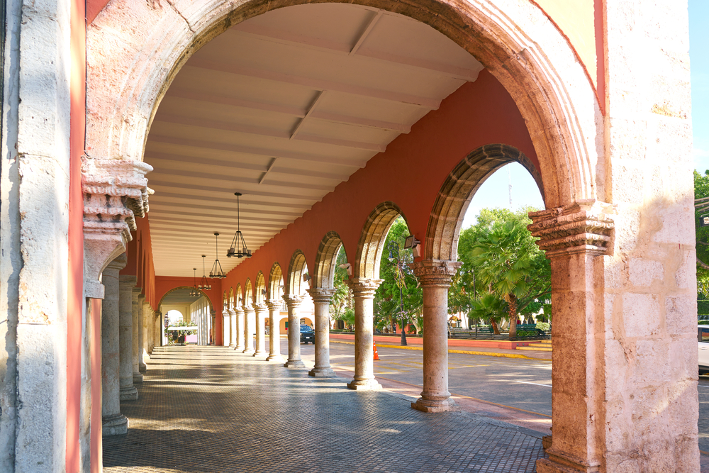 Pink marble arches cover a historical city arcade during the best time to travel to Merida Mexico