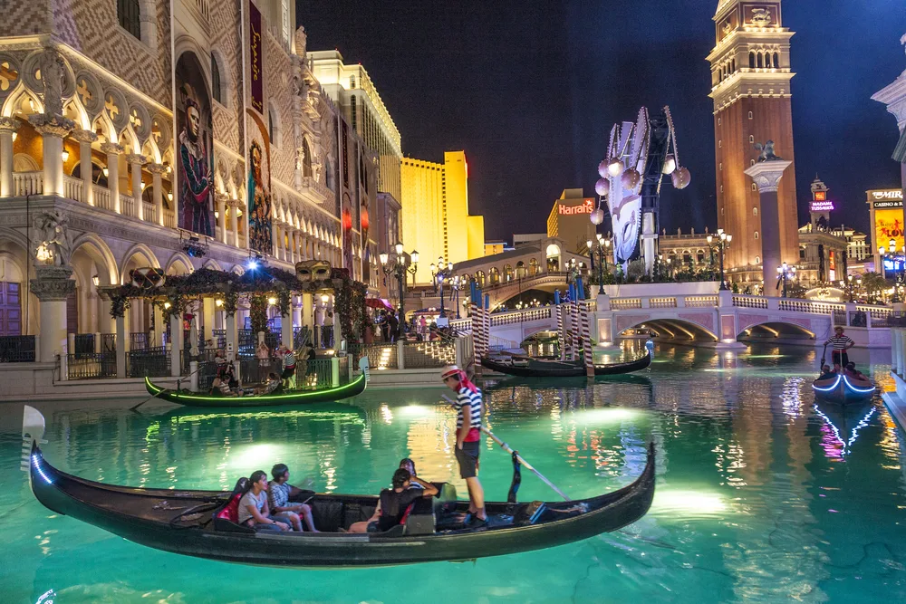 Photo of tourists in a gondola floating along in the water outside of the Venetian for a guide to the average Vegas trip cost