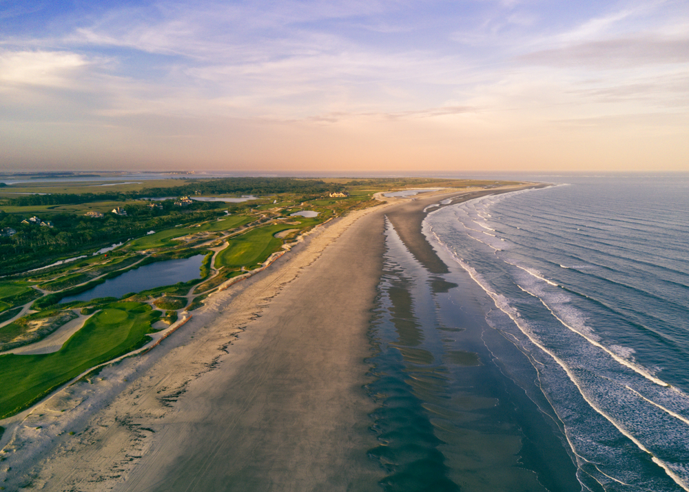Aerial drone view of Kiawah Island, South Carolina at sunset with empty shores and greenery for a list of the best beach vacations in the US