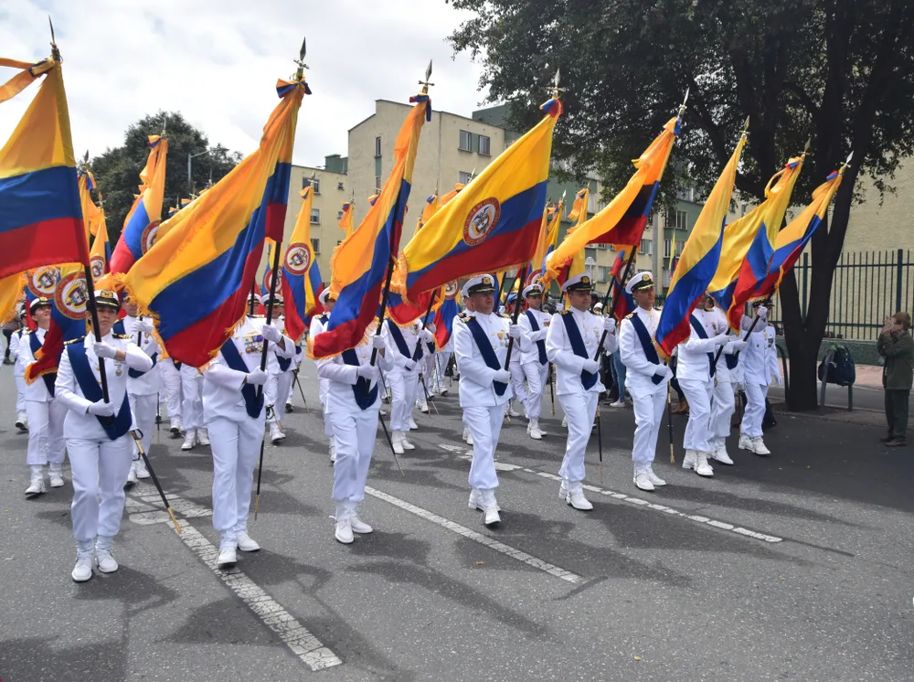 Photo of soldiers marching down the street during Colombia's Independence Day Parade in Bogota during the summer, the cheapest time to visit
