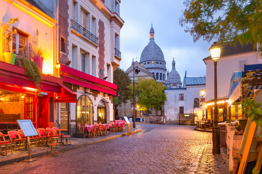As an image for a piece on the average Paris trip cost, the Place du Tertre with tables pictured outside a cafe, as seen in the early morning light