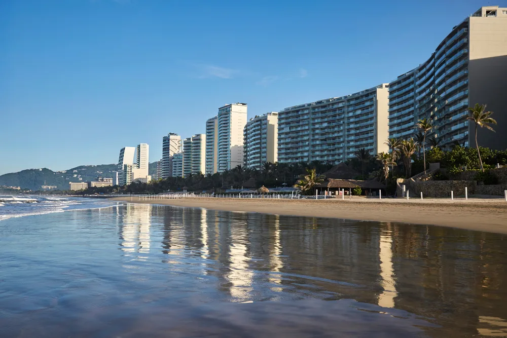 Diamante, one of the best parts of Acapulco in which to stay, pictured with still water in front of the resorts below a blue sky
