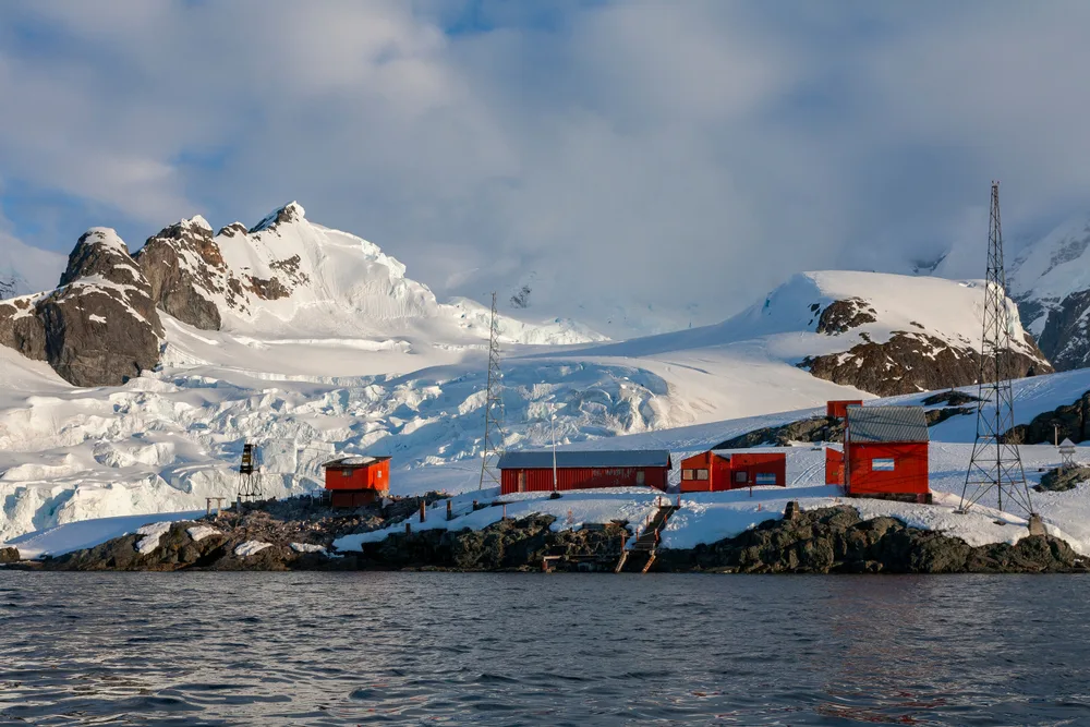 Small red buildings sitting on rocks in Antarctica