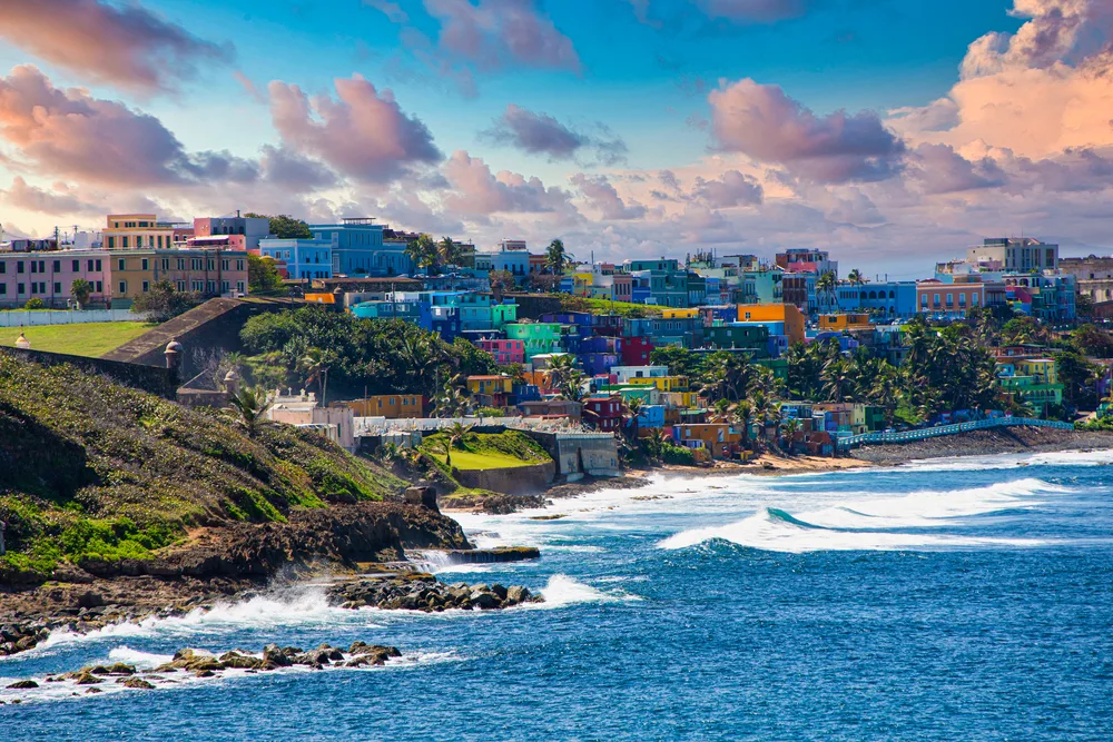 Colorful houses on the La Perla coast of Old San Juan Puerto Rico at sunset for a piece comparing Puerto Rico and the Dominican Republic