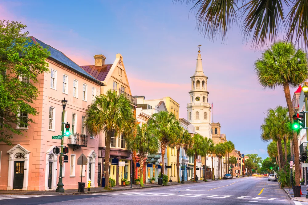 Charleston, SC French Quarter at twilight with palm trees and colorful buildings lining the street make it a great couples vacation spot in the US
