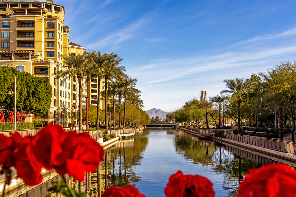 Waterfront of Scottsdale pictured with the canal running between buildings and a riverwalk with trees alongside it