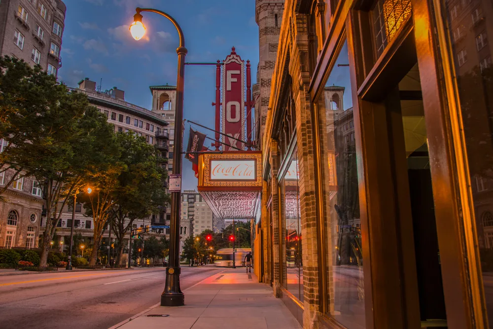 Photo of the Fox Theatre pictured at night with neon signs above the street for a guide titled Is Atlanta Safe to Visit