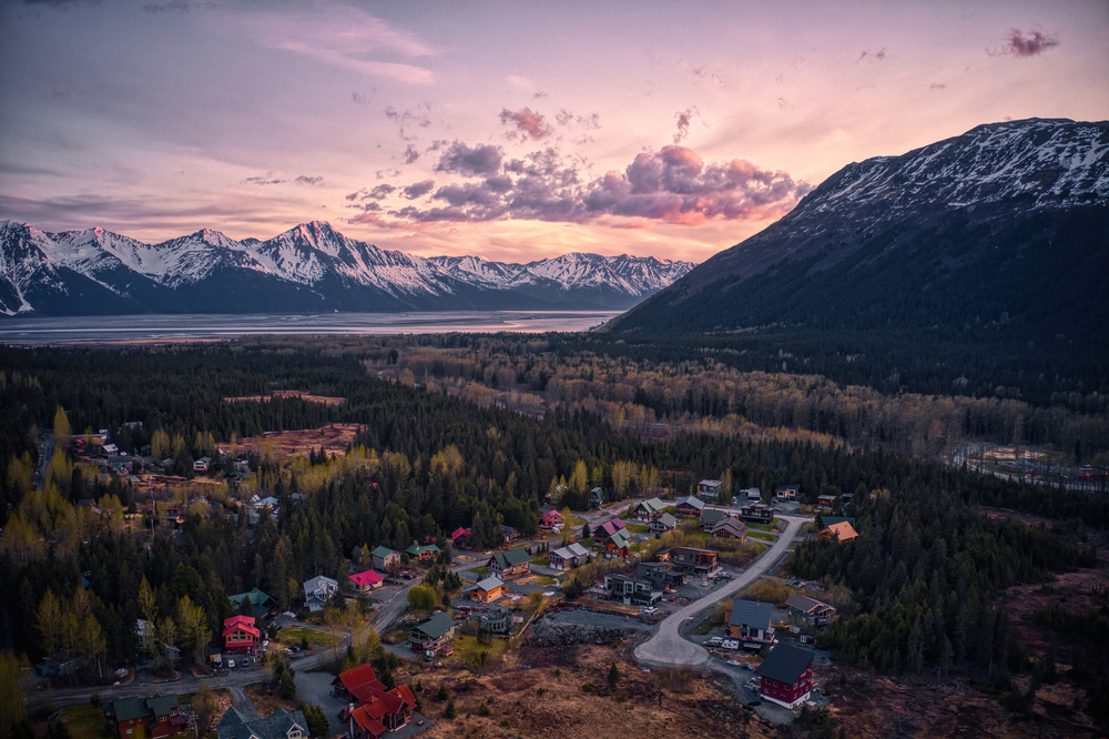 Aerial view of Girdwood, Alaska at dusk with mountains shown in the distance of a resort town that's one of the best couples vacations in the US