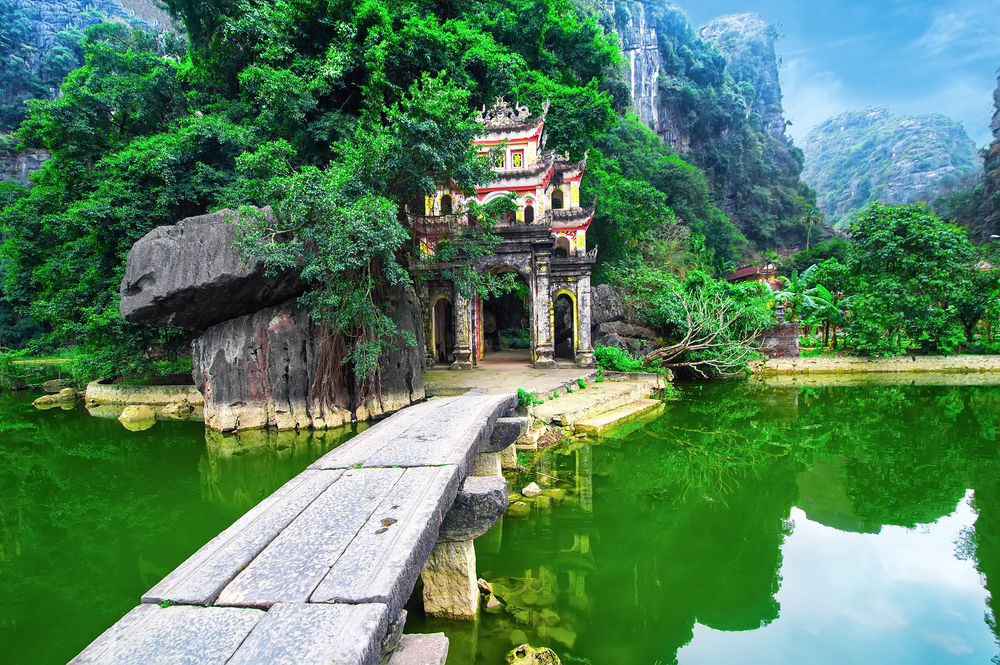 Gateway entrance to Bich Dong Pagoda in Ninh Binh Vietnam, one of the top 5 cheap places to travel worldwide, on a misty day in the jungle