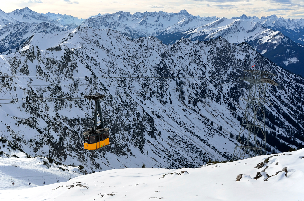 Yellow cable car traveling over Nebelhorn mountain, one of the best mountains in Germany, during a snowy winter
