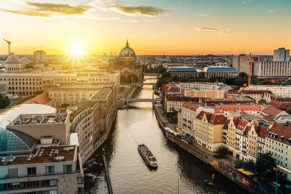 Aerial view of Berlin's skyline, boats on the river, and Berlin Cathedral at sunrise for a list of the best cities to visit in Europe