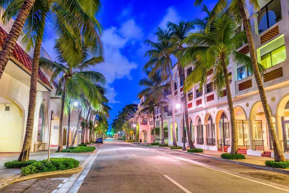 Colorful homes lining a palm-tree-lined street that is empty for a guide on what a trip to Florida costs