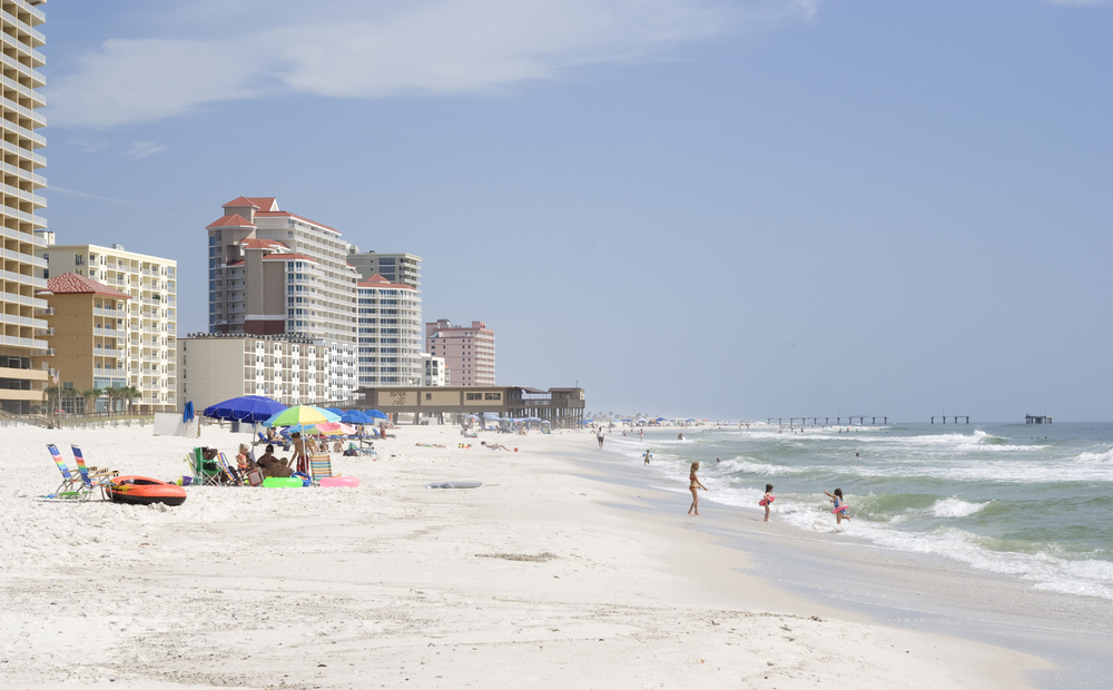 A few tourist playing in the water and enjoying the waves in Gulf Shores, Alabama