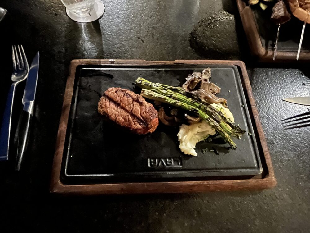Photo of green beans and a steak on a metal serving tray at Villa La Valencia in Cabo