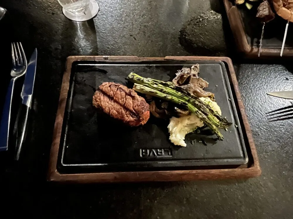 Photo of green beans and a steak on a metal serving tray at Villa La Valencia in Cabo