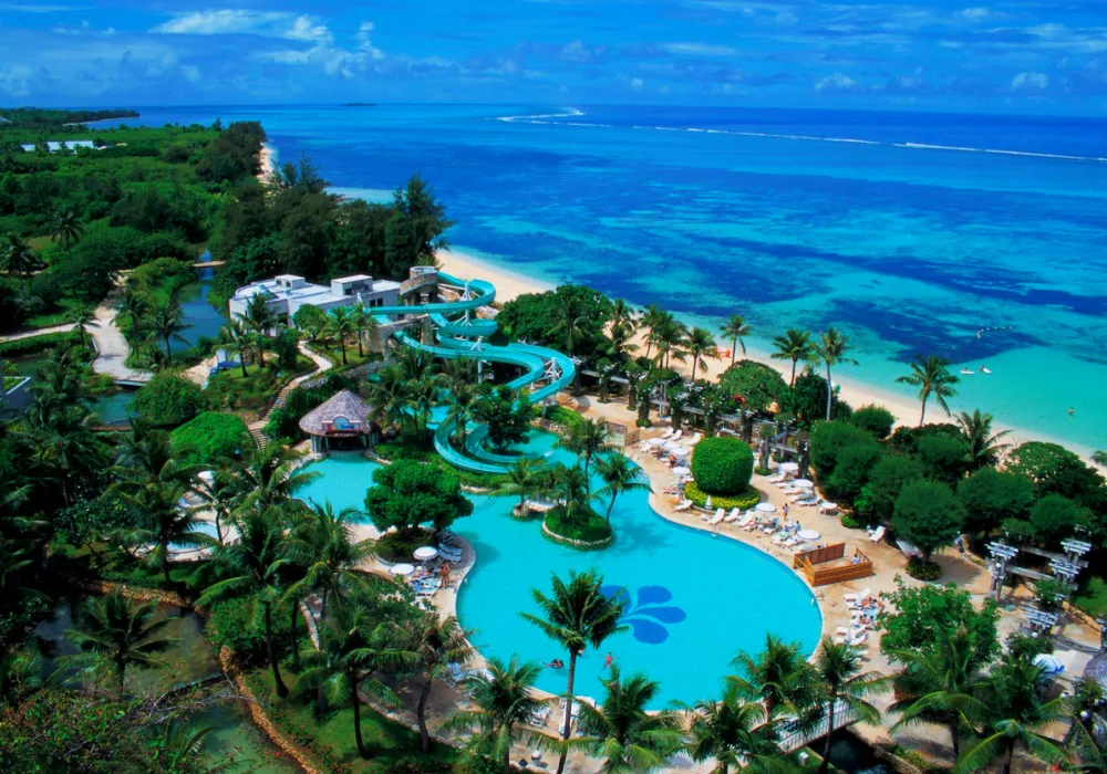 Aerial view of Saipan, Northern Mariana Islands resort pool area with palm trees and ocean views for a list of all-inclusive resorts that don't require a passport