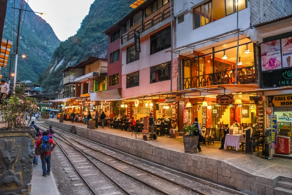 Hotels and restaurants beside an empty trains tracks in the country area, capture during a late afternoon for a piece on an article about trip cost to Machu Picchu.